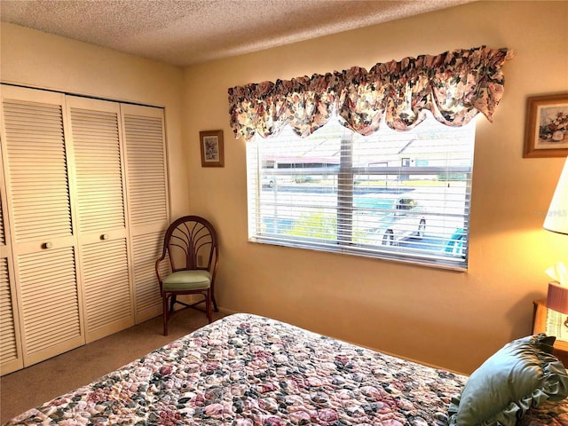 carpeted bedroom with a closet and a textured ceiling