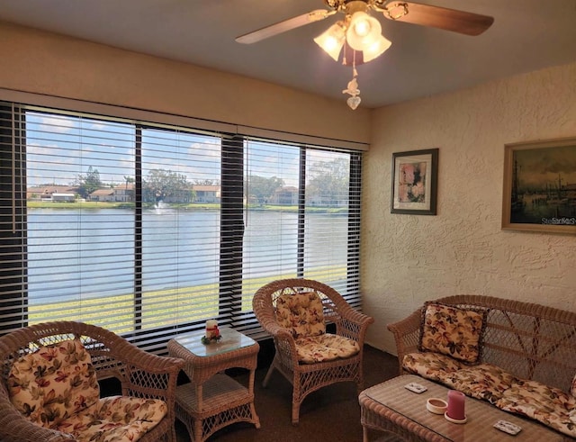 interior space with ceiling fan and a water view