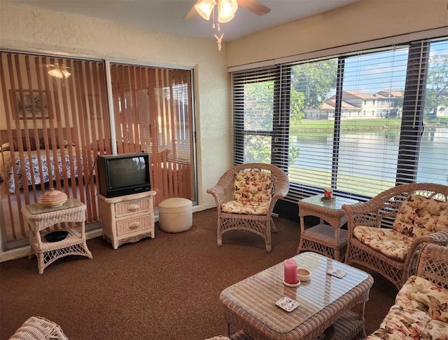 carpeted living room with ceiling fan