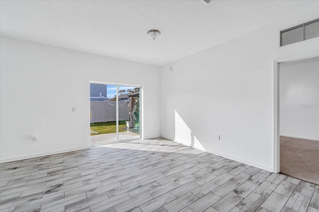 unfurnished room featuring a textured ceiling