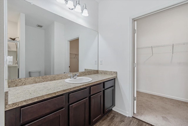 bathroom with vanity, toilet, and hardwood / wood-style floors