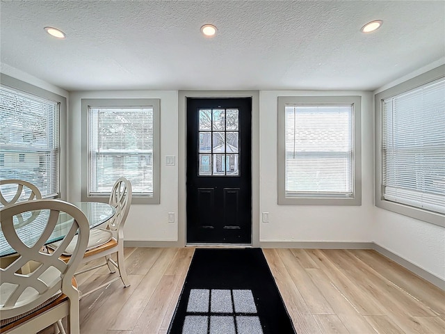 foyer featuring a textured ceiling and light wood-type flooring