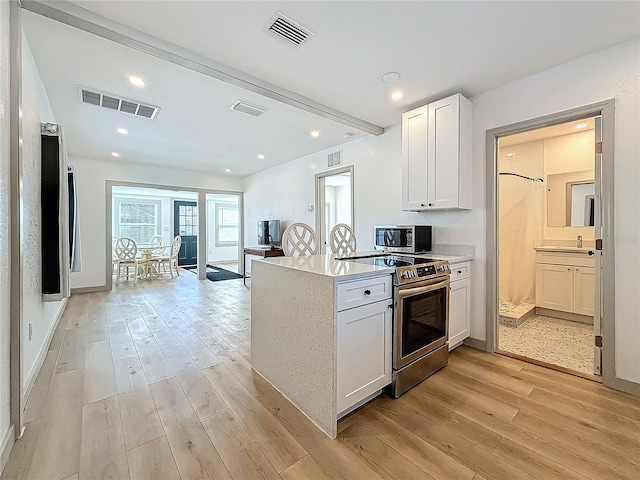 kitchen with white cabinets, stainless steel appliances, light stone countertops, beam ceiling, and light hardwood / wood-style flooring