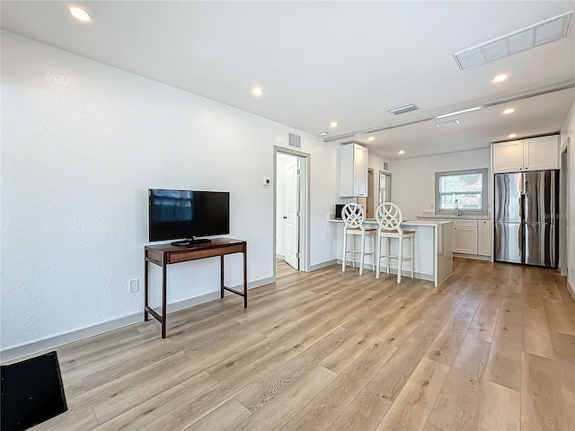 living room with sink and light wood-type flooring