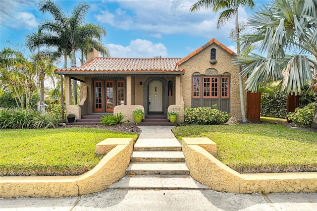 view of front of house featuring a front yard and french doors