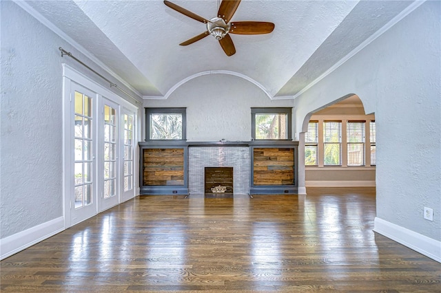 unfurnished living room with dark hardwood / wood-style flooring, a fireplace, a textured ceiling, and vaulted ceiling