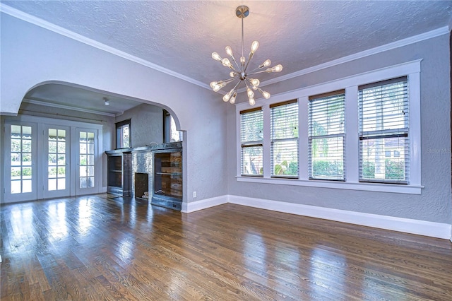 unfurnished living room featuring crown molding, dark hardwood / wood-style floors, a textured ceiling, and a wealth of natural light