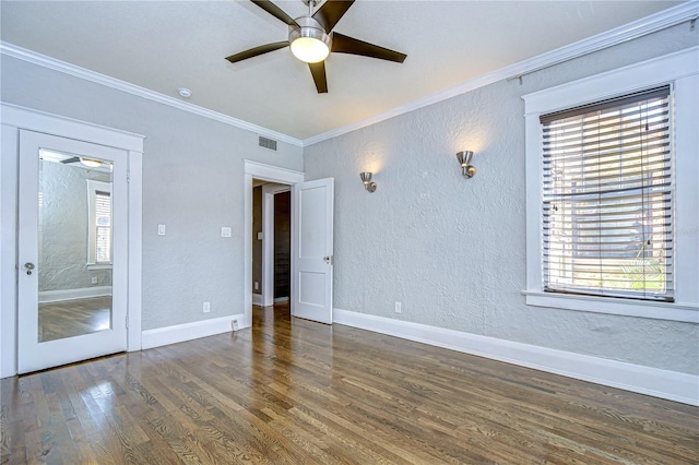 spare room featuring dark hardwood / wood-style flooring, crown molding, and a healthy amount of sunlight