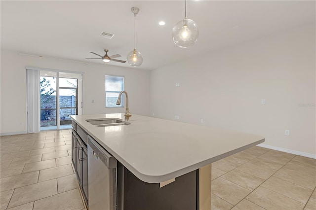 kitchen with light tile patterned flooring, sink, dishwasher, pendant lighting, and a kitchen island with sink