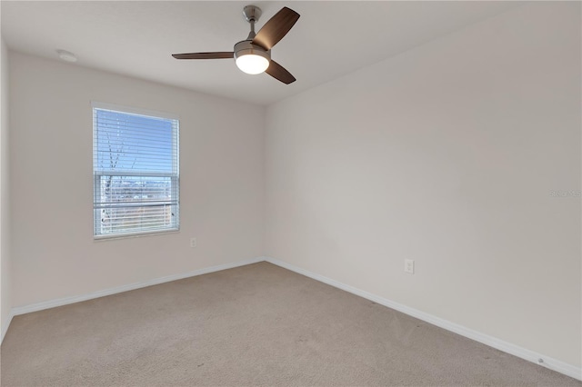 carpeted spare room featuring ceiling fan