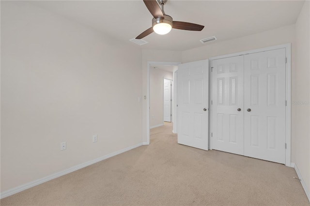 unfurnished bedroom with light carpet, a closet, and ceiling fan