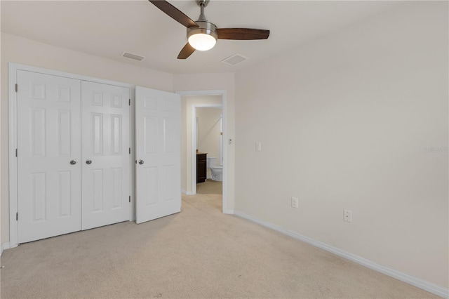 unfurnished bedroom featuring ceiling fan, light colored carpet, and a closet