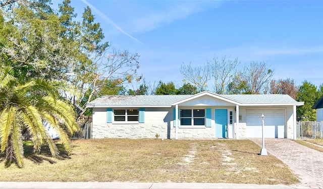 single story home featuring a garage and a front yard