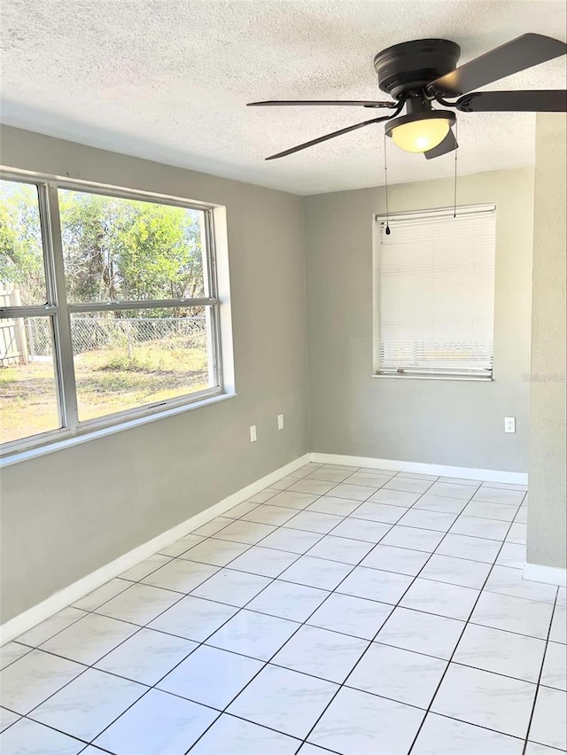 tiled spare room with ceiling fan and a textured ceiling