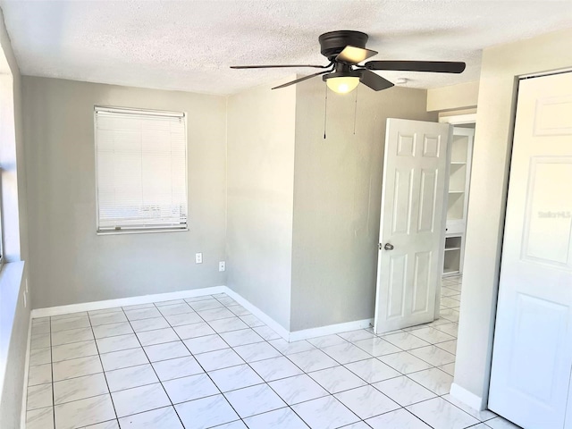 unfurnished room featuring ceiling fan and a textured ceiling