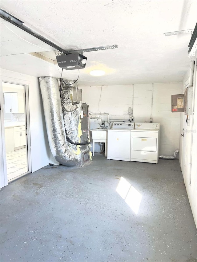 garage with a garage door opener, sink, and independent washer and dryer