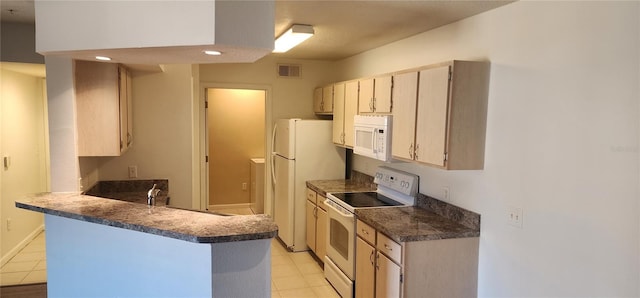 kitchen featuring sink, light tile patterned floors, white appliances, and kitchen peninsula