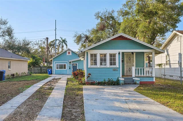 bungalow with a porch and a front lawn