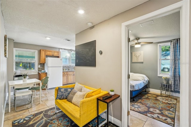 tiled living room featuring sink and a textured ceiling