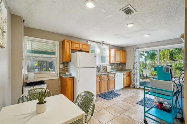 kitchen with sink, white appliances, decorative backsplash, and light tile patterned floors