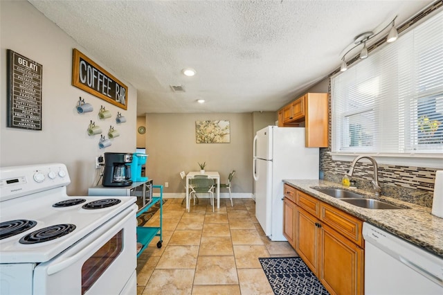 kitchen featuring white appliances, sink, decorative backsplash, and a textured ceiling