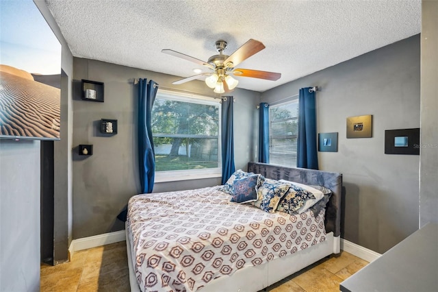 bedroom with ceiling fan and a textured ceiling