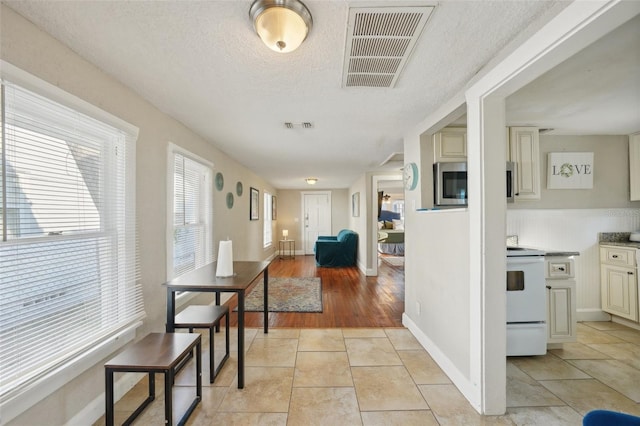 interior space with a textured ceiling and light tile patterned flooring