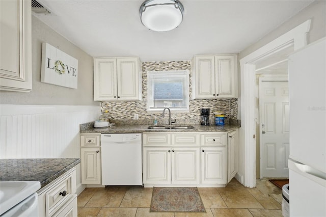 kitchen with white cabinetry, white appliances, dark stone counters, and sink