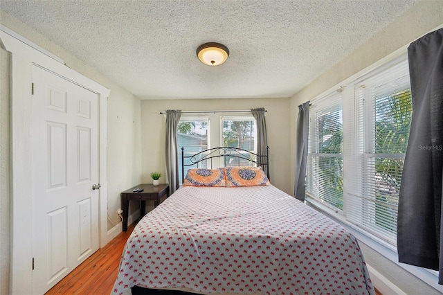 bedroom featuring hardwood / wood-style flooring and a textured ceiling