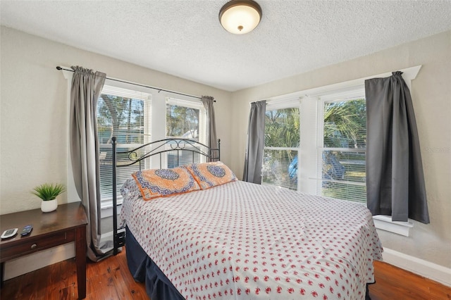 bedroom with dark hardwood / wood-style flooring and a textured ceiling