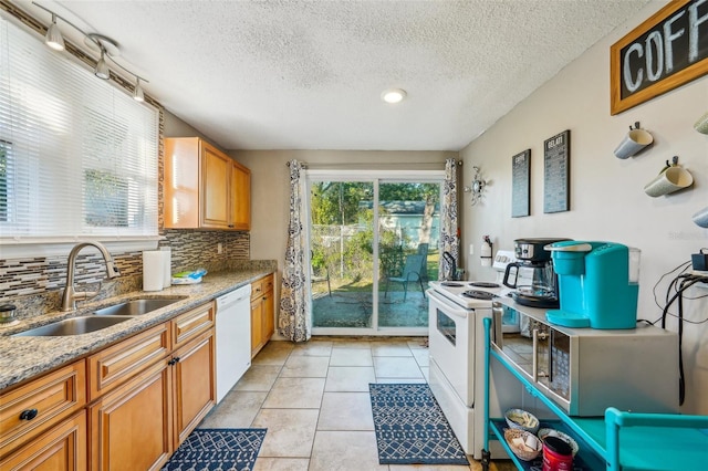 kitchen with plenty of natural light, sink, white appliances, and decorative backsplash