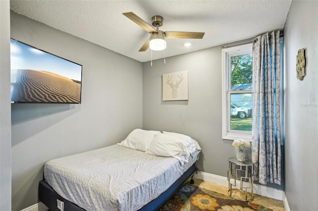 bedroom featuring ceiling fan and a textured ceiling