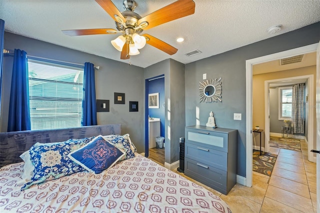 tiled bedroom with ceiling fan and a textured ceiling