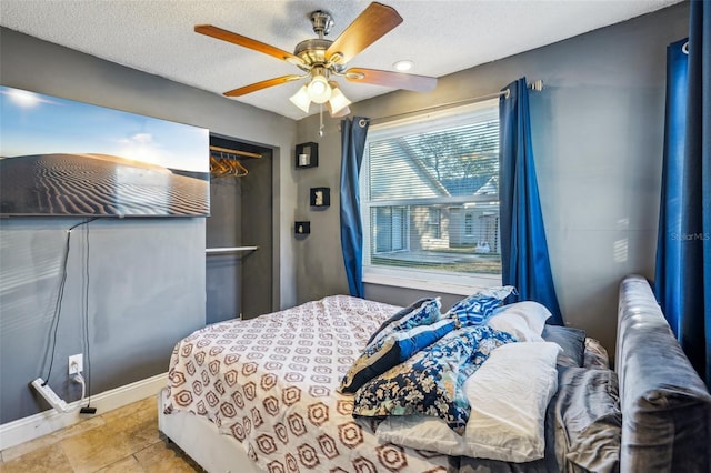 bedroom with ceiling fan and a textured ceiling