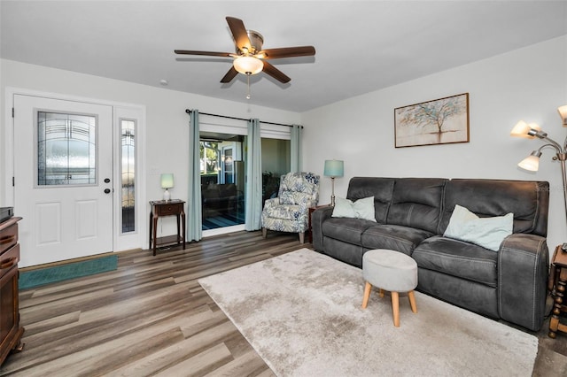 living room featuring ceiling fan and dark hardwood / wood-style floors