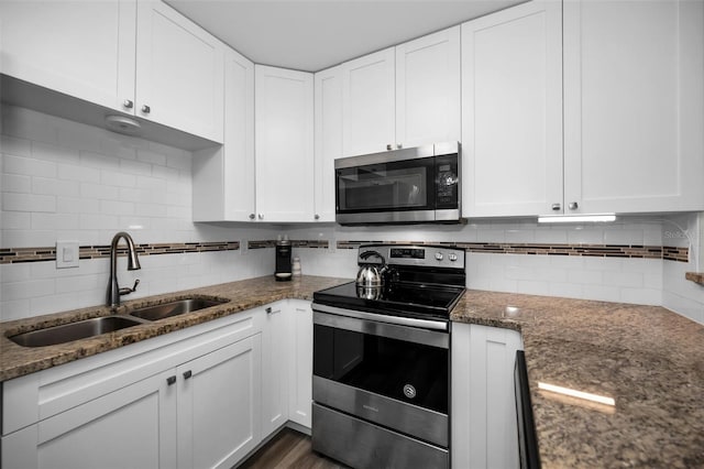 kitchen with white cabinetry, sink, dark stone counters, and appliances with stainless steel finishes