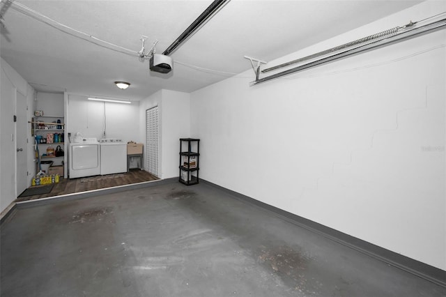 garage featuring sink, a garage door opener, and washer and dryer