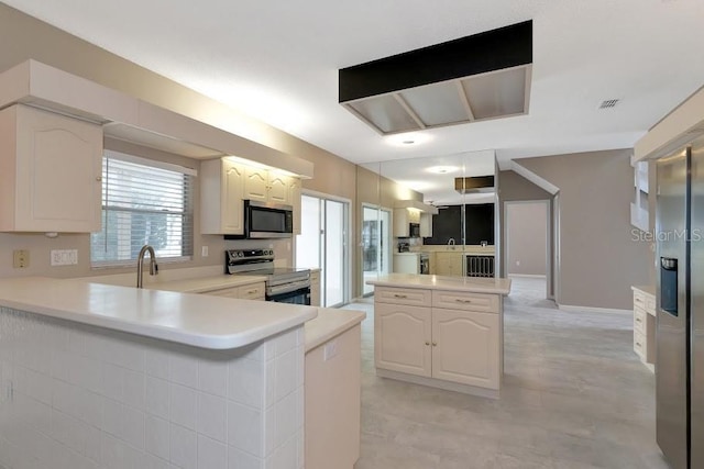 kitchen featuring white cabinetry, stainless steel appliances, kitchen peninsula, and sink