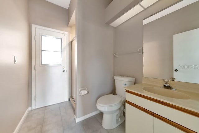 bathroom with tile patterned flooring, vanity, a shower with shower door, and toilet