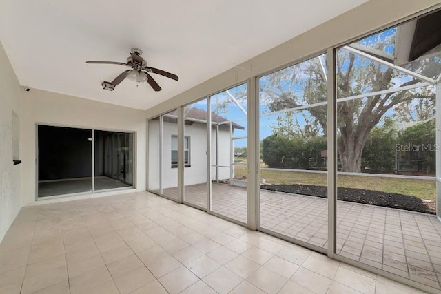 unfurnished sunroom featuring ceiling fan