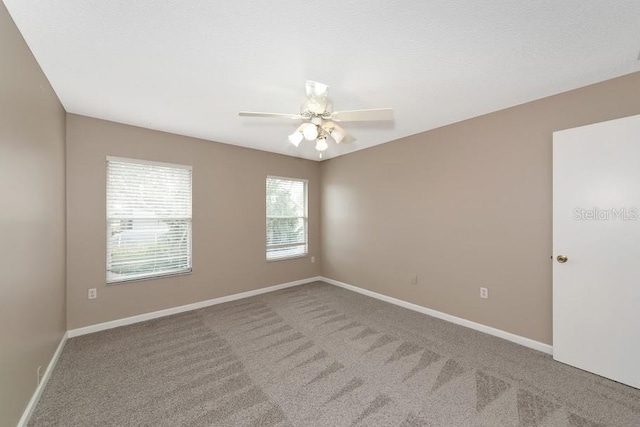 empty room with carpet flooring and ceiling fan