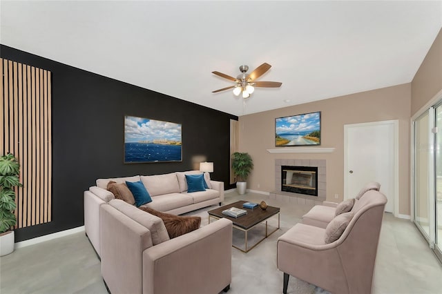 living room with a tiled fireplace and ceiling fan