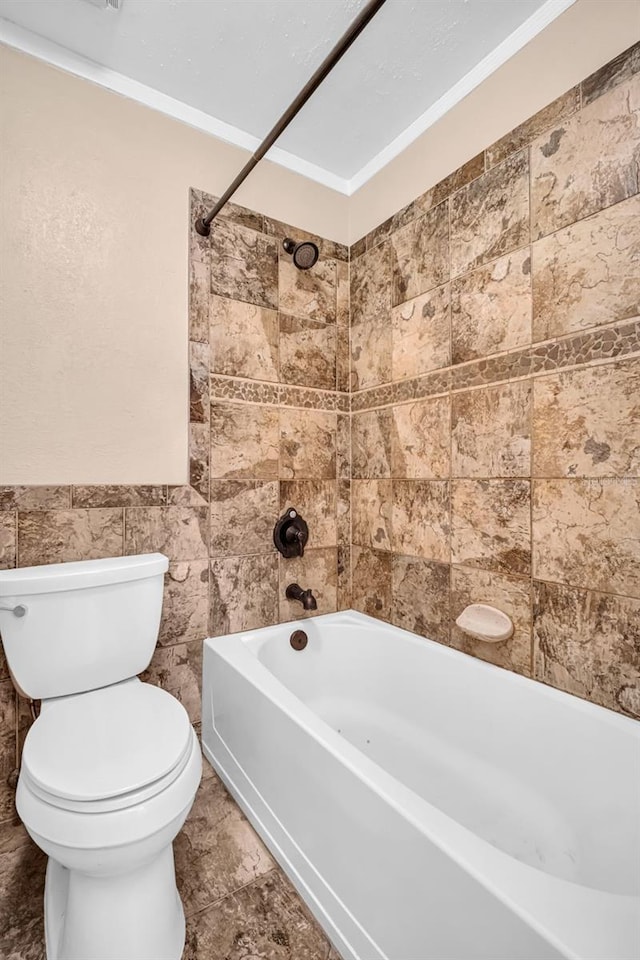 bathroom featuring tile walls, tiled shower / bath combo, crown molding, and toilet