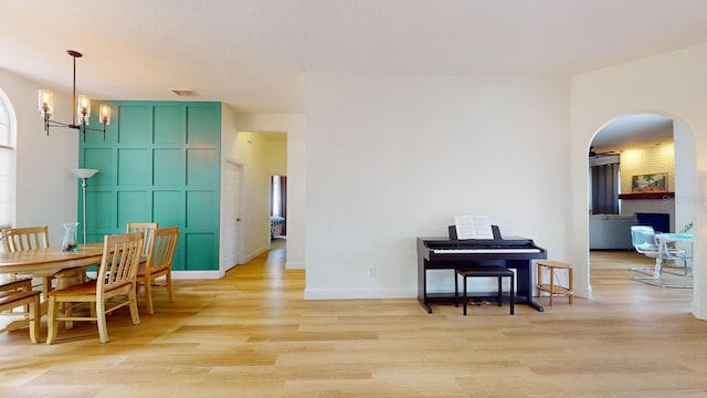 dining space with light hardwood / wood-style flooring and a notable chandelier