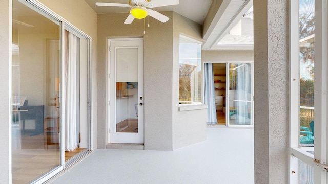 unfurnished sunroom with ceiling fan