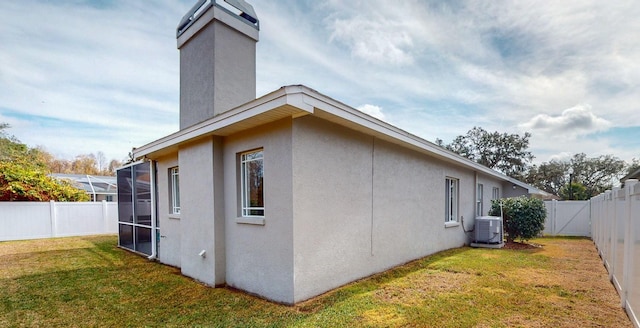 view of property exterior with a yard, central AC, and a lanai