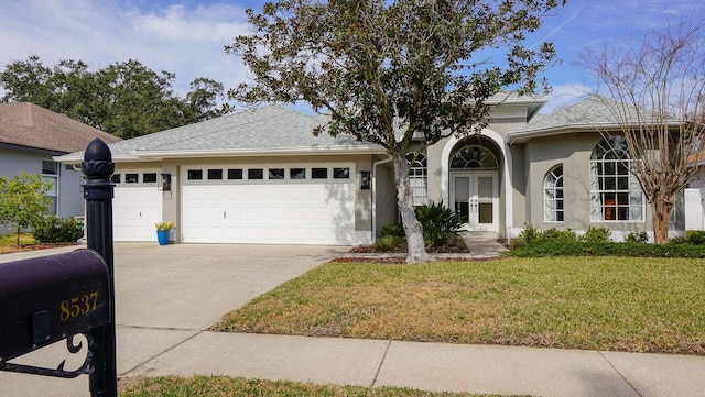 ranch-style house with a garage and a front lawn