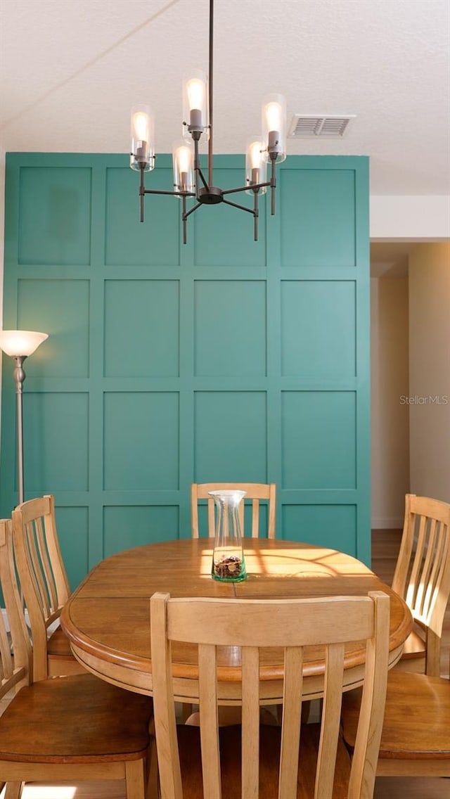 dining room featuring wood-type flooring and a chandelier