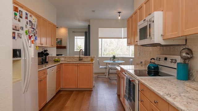 kitchen with tasteful backsplash, sink, light wood-type flooring, light brown cabinets, and white appliances