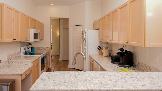 kitchen featuring white appliances and light brown cabinetry